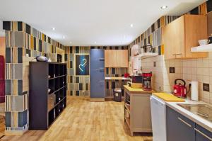 a large kitchen with wooden cabinets and a blue refrigerator at Art-Wohnung in Beierstedt