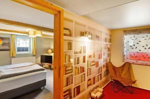 a bedroom with a bed and a wall of books at Art-Wohnung in Beierstedt