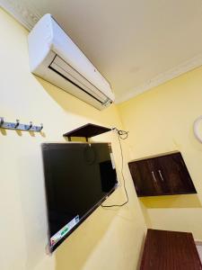 a flat screen tv hanging on a wall with a fan at MSN-Gate1Temple in Srikalahasti