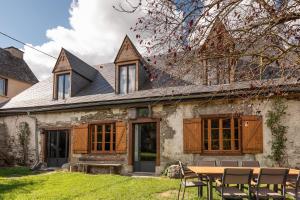 a house with a table and chairs in front of it at La Ketzerie à Adervielle in Adervielle