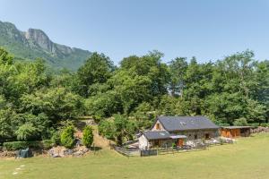a house in a field with mountains in the background at Gîte Lodge L'authentik in Accous
