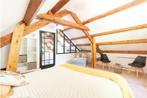 a bedroom with wooden ceilings and timber beams at Gîte Lodge L'authentik in Accous