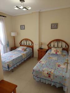 a bedroom with two beds in a room at Dúplex El Divino in Los Alcázares +16 photos