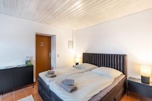 a bedroom with a large bed with two towels on it at Haus Ersfeld – Gartenstudio in Bad Teinach-Zavelstein