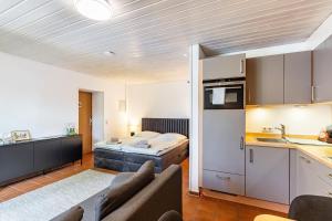 a kitchen and living room with a couch and a bed at Haus Ersfeld – Gartenstudio in Bad Teinach-Zavelstein