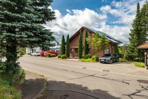 a house with a car parked on the side of a road at Haus Ersfeld – Gartenstudio in Bad Teinach-Zavelstein