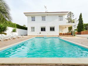 a villa with a swimming pool in front of a house at Naizan in L'Ametlla de Mar