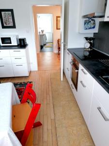 a kitchen with white cabinets and a wooden floor at Villa Bulla-ÿ in Bullay