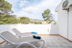 a white chair on a balcony with a view at Can Botana 10 in Cala de Sant Vicenc