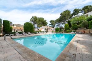 a swimming pool in a yard with chairs and trees at Can Botana 10 in Cala de Sant Vicenc