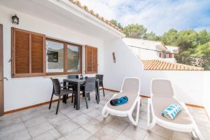 a patio with a table and chairs and a window at Can Botana 10 in Cala de Sant Vicenc