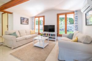 a living room with two couches and a tv at Can Botana 10 in Cala de Sant Vicenc
