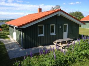 a green building with an orange roof and a picnic table at Skipper-Lodge Süd in Kosel