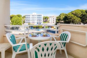 a balcony with chairs and a table with food on it at Apartamento Grillo in Cala Ratjada