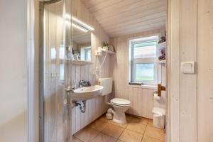 a bathroom with a sink and a toilet and a window at Skipper-Lodge Süd in Kosel +11 photos