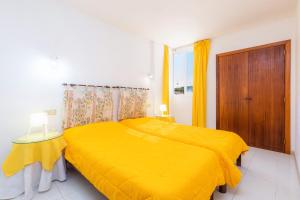 a bedroom with a yellow bed and a window at Apartamento Grillo in Cala Ratjada