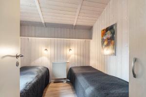 two beds in a room with wooden walls at Skipper-Lodge Süd in Kosel