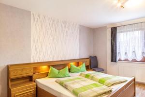 a bedroom with a large bed with green pillows at Ferienwohnung Göpfert in Weyhers