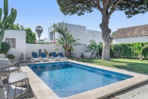 a pool with chairs and a tree in a yard at El Rincon del Che in Zahora