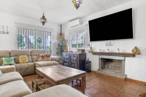 a living room with a flat screen tv above a fireplace at El Rincon del Che in Zahora