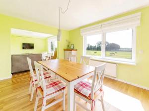 a dining room with a wooden table and chairs at Ferienhaus Kuhweid in Drochtersen +13 photos