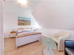 a white bedroom with a bed and a couch at Ferienhaus Kuhweid in Drochtersen