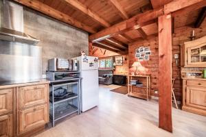 a kitchen with a white refrigerator and wooden walls at Chalet 6p Confort - L'ours blanc in Verchaix