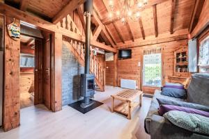 a living room with a fireplace in a log cabin at Chalet 6p Confort - L'ours blanc in Verchaix