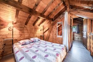 a bedroom with a bed in a wooden room at Chalet 6p Confort - L'ours blanc in Verchaix