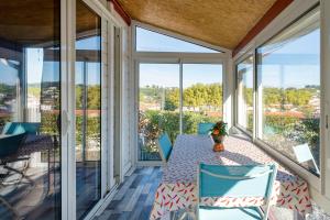 a screened in porch with a table and chairs at Petite maison Ortalon - Hasparren in Hasparren
