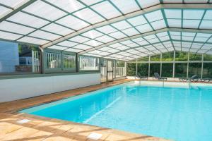 an indoor swimming pool with a glass ceiling at Petite maison Ortalon - Hasparren in Hasparren +12 photos