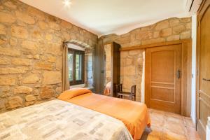 a bedroom with a bed in a stone wall at El Puig De Fonollet in Puigreig +33 photos