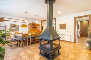 a kitchen and dining room with a wood stove at El Puig De Fonollet in Puigreig