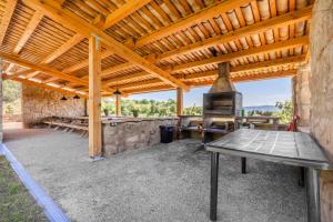 a patio with a table and an outdoor grill at El Puig De Fonollet in Puigreig
