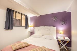 a bedroom with a white bed and a purple wall at Les Glycines 1 in Les Épesses