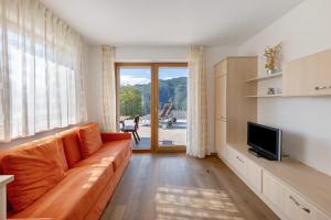 a living room with a couch and a television at Obertrisaierhof Wohnung 1 in Fie allo Sciliar