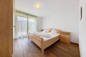 a bedroom with a bed and a large window at Obertrisaierhof Wohnung 1 in Fie allo Sciliar