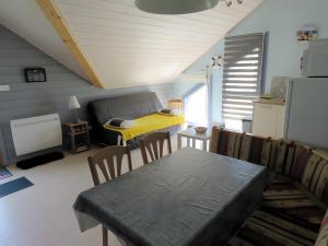 a living room with a table and a yellow at Les Hirondelles du Cap in Plévenon +15 photos