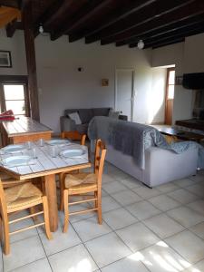 a living room with a couch and a table and chairs at Gîte Le Guerichet in Betton +13 photos