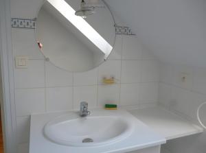 a bathroom with a white sink and a mirror at Gîte Le Guerichet in Betton