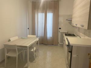 a kitchen with a table and chairs and a kitchen with a stove at Massimo Holiday house in Acquarica del Capo