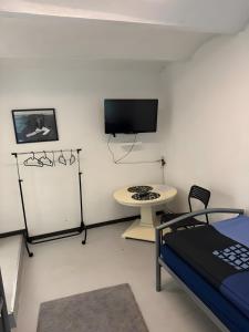 a room with a bed and a tv and a table at Monteurswohnung Rothentor4 in Dorf Mecklenburg