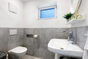 a bathroom with a sink and a toilet and a window at Fewo am Mühlenbach in Wehr +11 photos