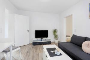 a living room with a couch and a tv at Fewo am Mühlenbach in Wehr
