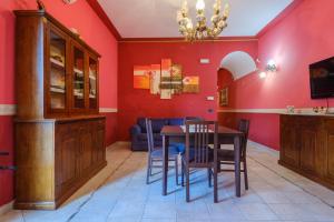 a dining room with red walls and a table and chairs at Villa Chanel in Monteroni di Lecce