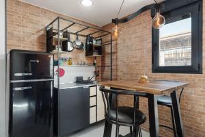 a kitchen with a black refrigerator and a table at La Mihilla in Málaga