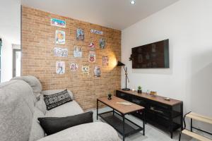 a living room with a couch and a brick wall at La Mihilla in Málaga