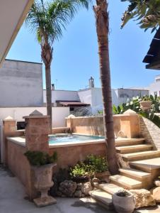 a courtyard with palm trees and a swimming pool at Villa Chanel in Monteroni di Lecce