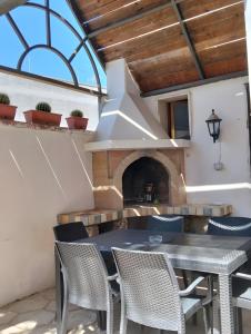 a patio with a table and chairs and a fireplace at Villa Chanel in Monteroni di Lecce