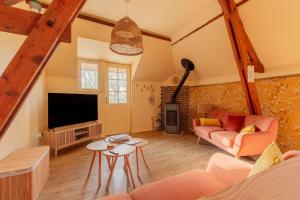 a living room with a couch and a tv at La Pause Picarde - Baie De Somme 2 in Franleu